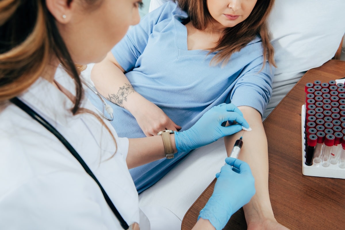 image of a woman giving a blood sample to determine if she has autoimmune disease